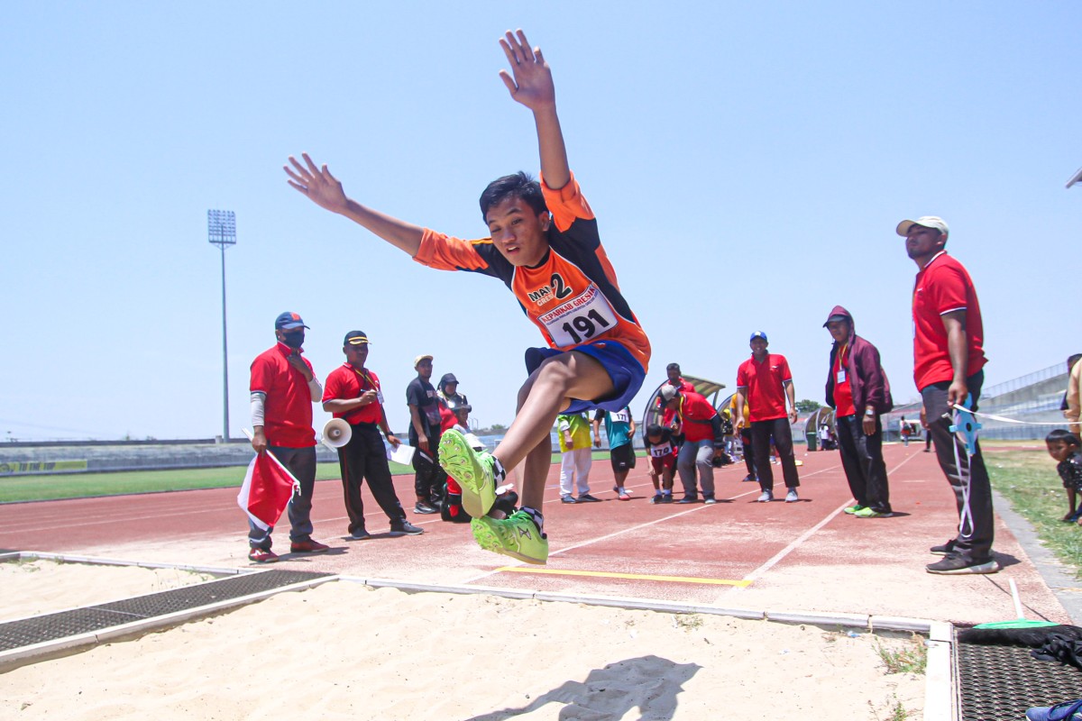 Seorang atlet disabilitas sedang mengikuti perlombaan loncat jauh di ajang paralympic tingkat Kabupaten Gresik (Foto: Sahlul Fahmi/jatimnow.com)