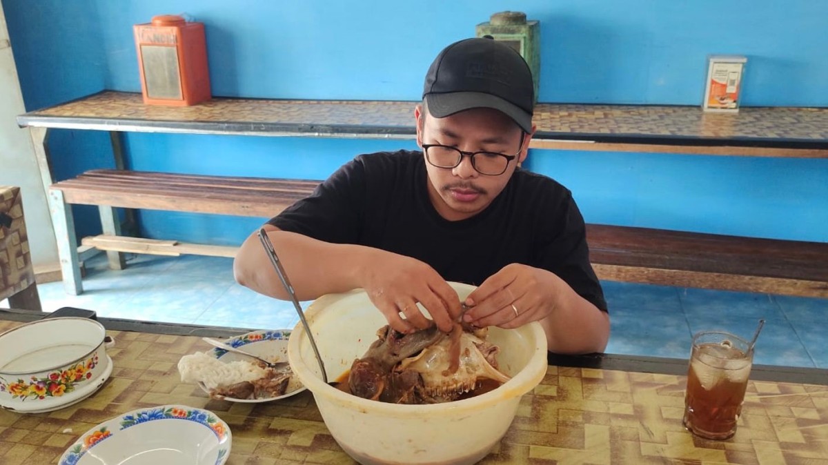 Pelanggan menikmati kepala kambing di warung kikil Mbah Murtini. (Foto: Yanuar Dedy/jatimnow.com)
