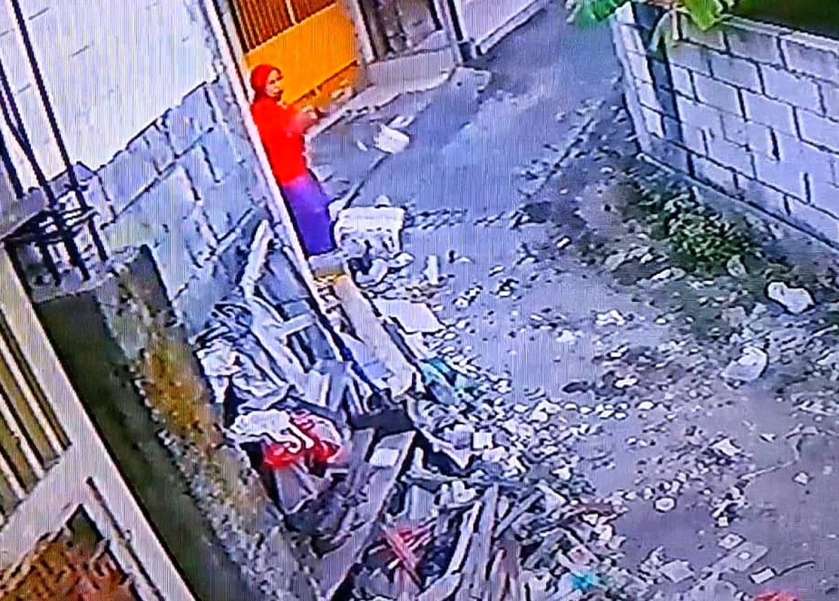 Aksi Masriah saat membuang sampah dapur terekam CCTV. (Foto: tangkapan layar medsos)