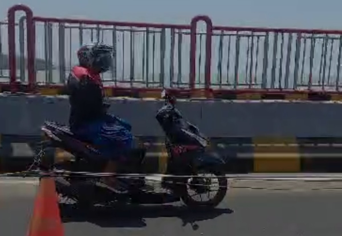 Tangkapan layar pengendara motor yang melepas setir saat mengemudi. (Foto:  Fathor Rahman/jatimnow.com)