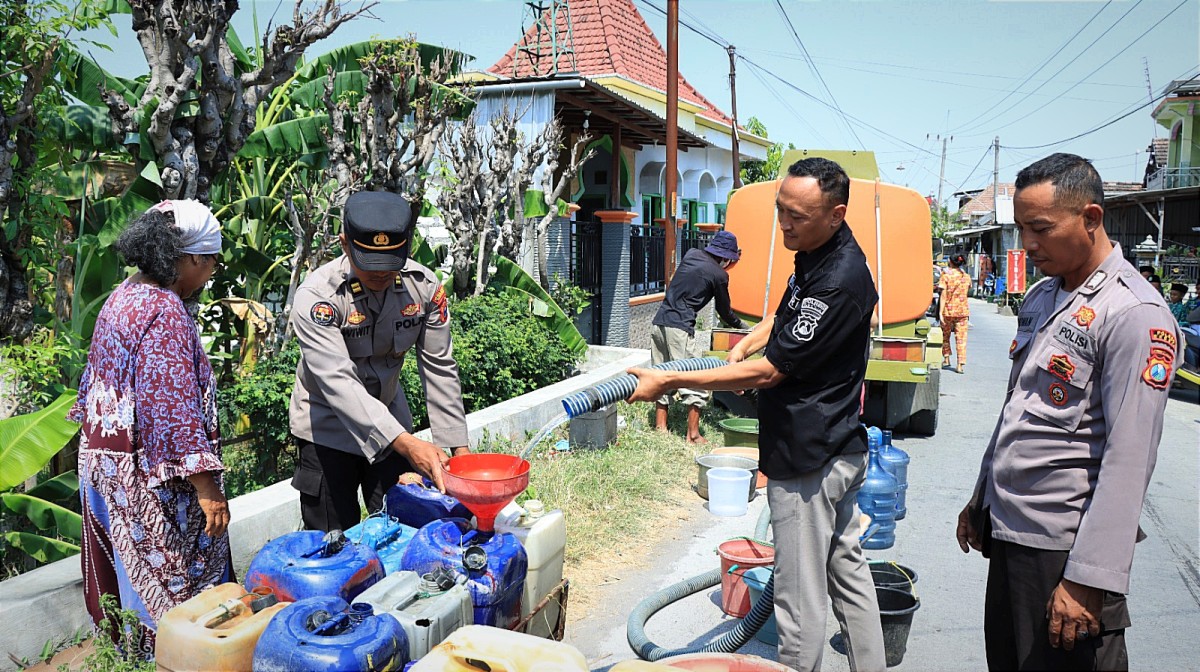 Polres Gresik bagikan air bersih di Desa Tumapel, Duduksampeyan, Gresik. (Foto: Humas Polres Gresi for jatimnow.com)