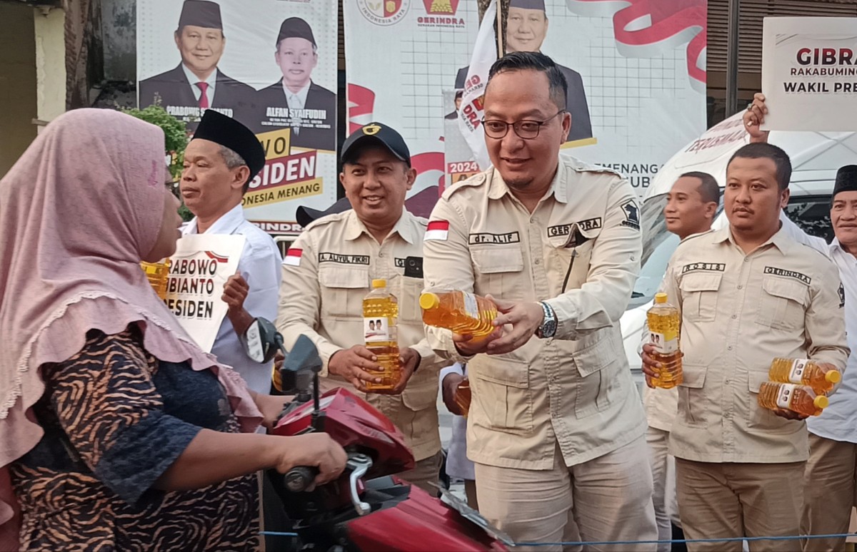 Ketua DPC Gerindra Gresik, Asluchul Alif beserta jajarannya saat membagikan minyak goreng gratis kepada pengguna jalan yang melintas di depan Posko Pemenangan Prabowo Subianto (Foto: Sahlul Fahmi/jatimnow.com)