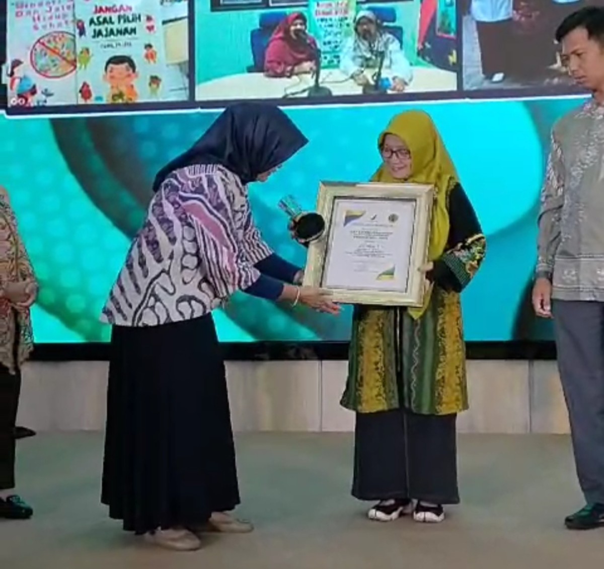Kepala Sekolah SMPN 1 Lamongan, Yayuk Setia Rahayu saat menerima penghargaan pemenang lomba pangan sehat dari BPOM. (Foto : SMPN 1 Lamongan for jatimnow.com)