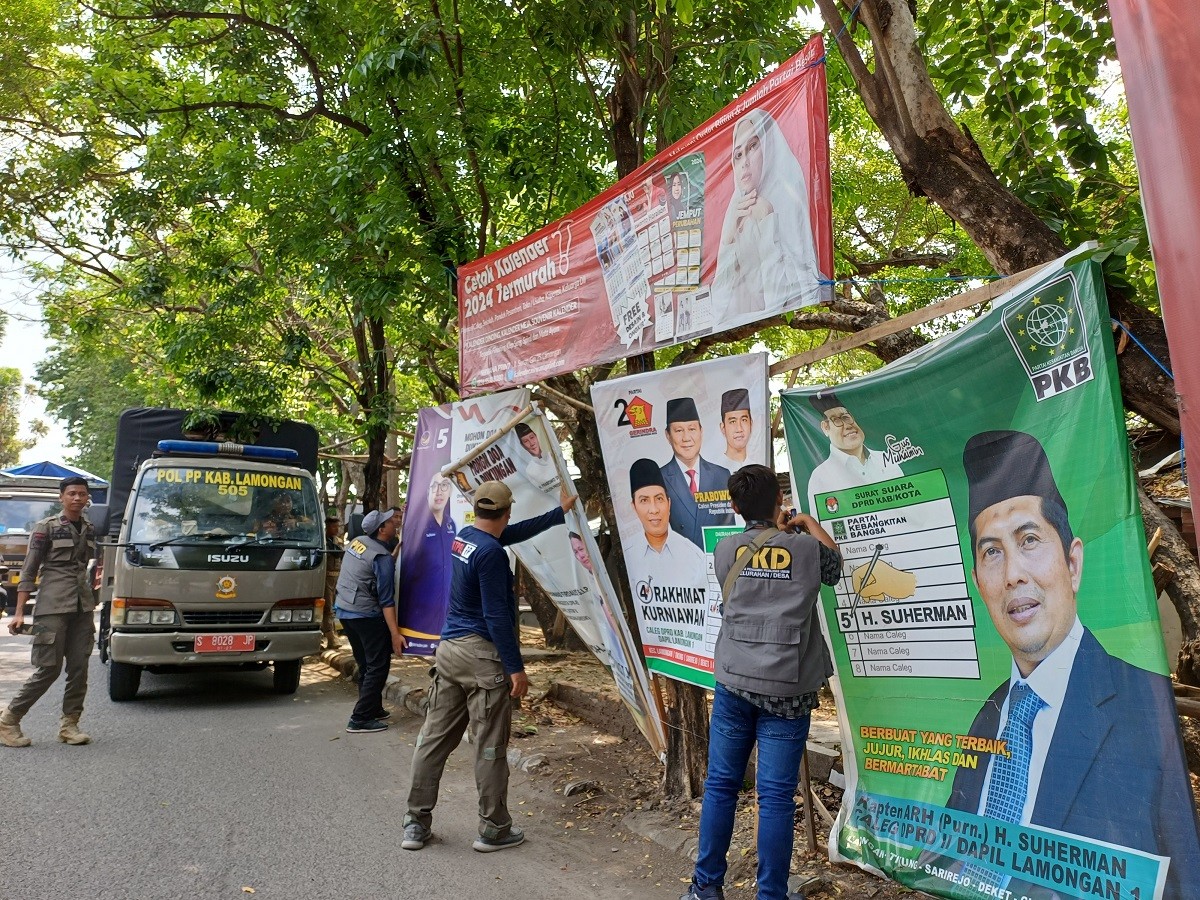 Bawaslu Lamongan saat menertibkan APK luar di Jl. Kusuma Bangsa pasar ikan Lamongan. (Foto : Adyad Ammy Iffansah/jatimnow.com)