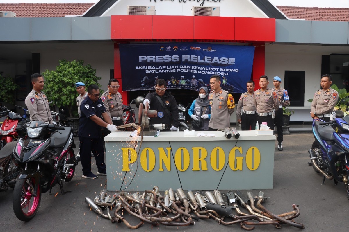 Kapolres Ponorogo, AKBP Wimboko, bersama Kasatlantas Polres Ponorogo, AKP J Nugroho, dalam penghancuran knalpot brong menggunakan alat gergaji.
