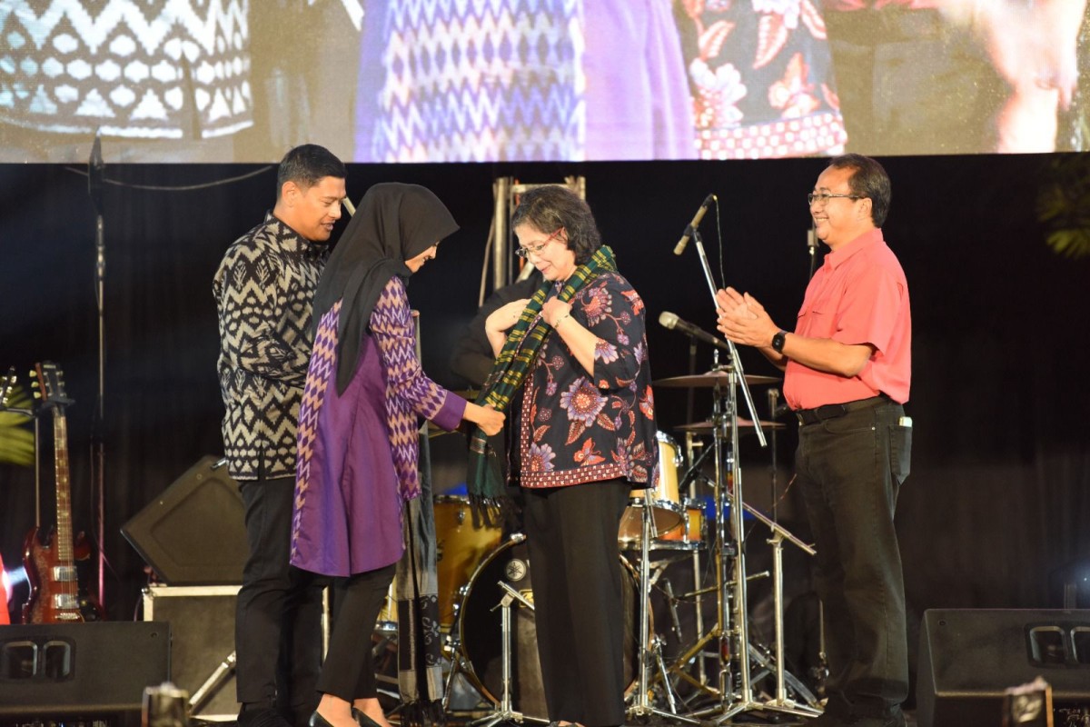 Bunda Fey, istri Mas Abu mengalungkan kain tenun ikat Bandar Kidul khas Kediri pada Zanariah. (Foto: Pemkot Kediri for jatimnow.com)