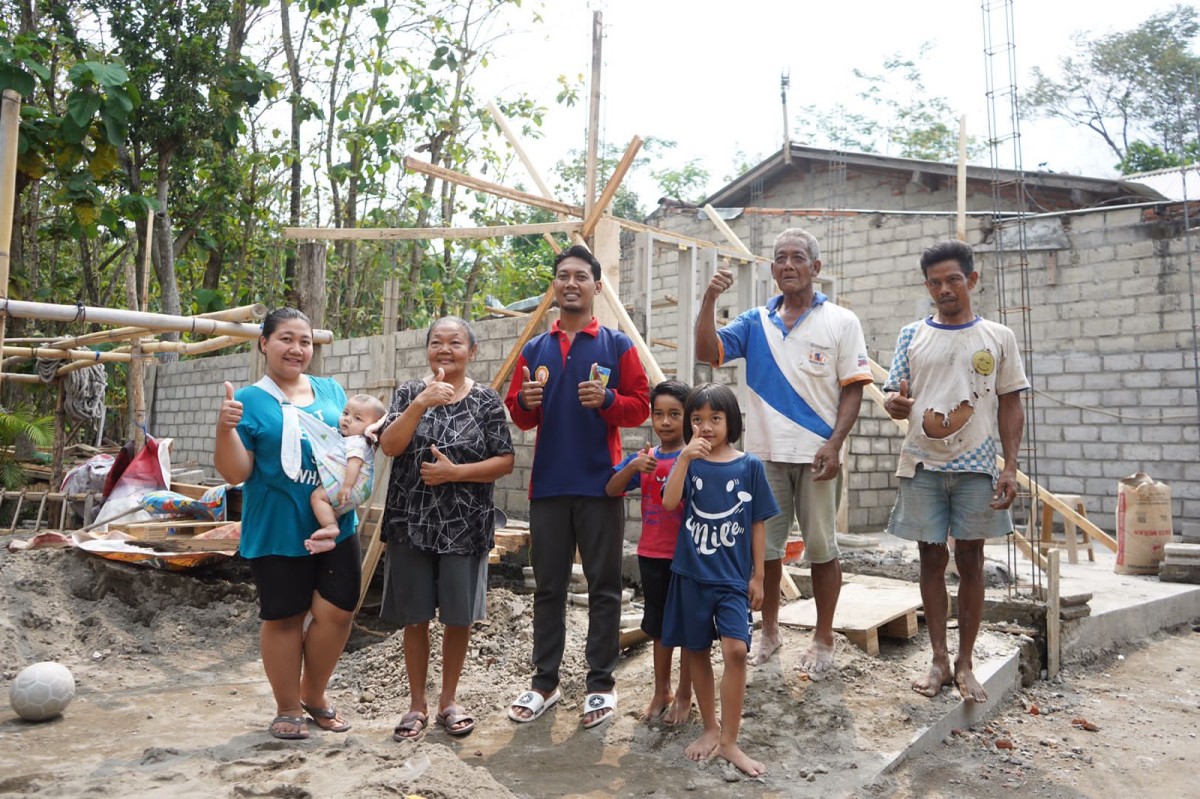 Anggit dan keluarga di depan calon rumah barunya. (Foto: Humas Pemkab Kediri/jatimnow.com)