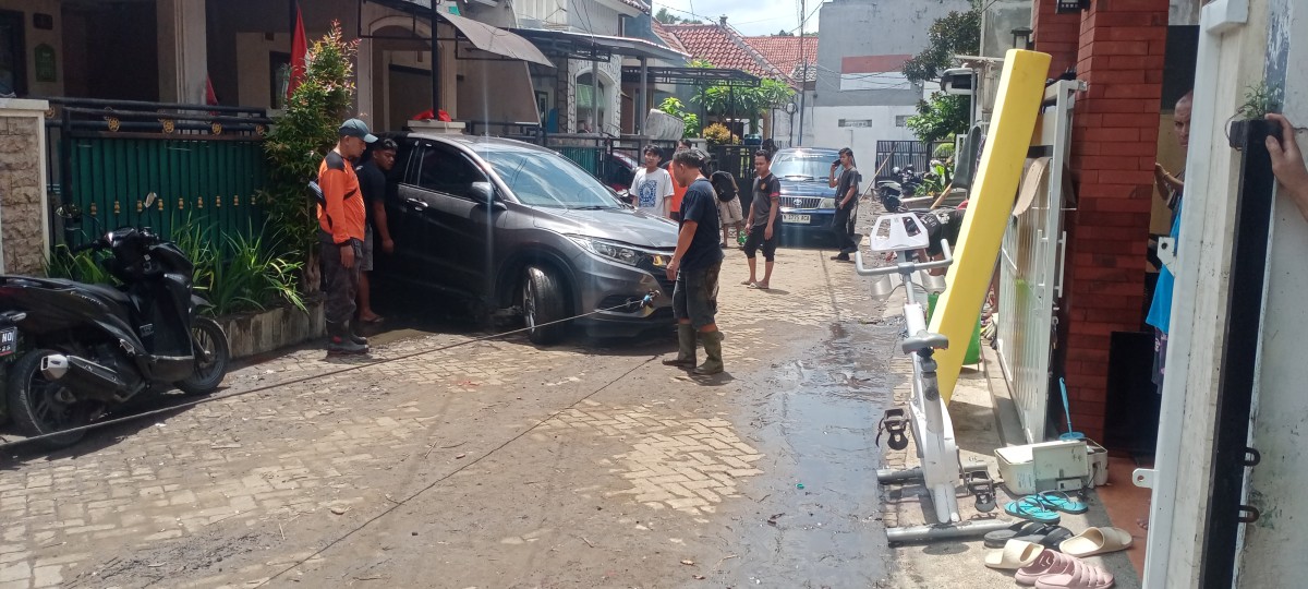 Kondisi warga Perumahan Sigura Residence masih sibuk membersihkan rumahnya masing-masing. (Foto: Gerhana/jatimnow.com)