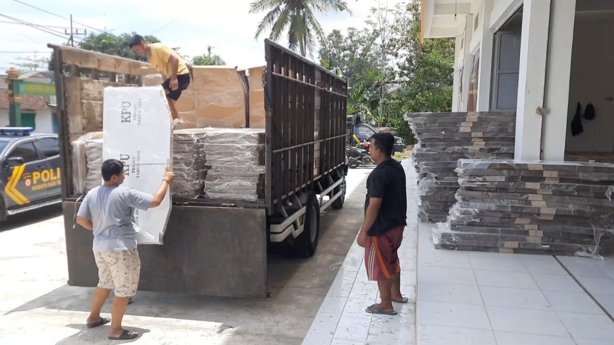Petugas menurunkan kiriman logistik bilik suara. (Foto: Bramanta Pamungkas/jatimnow.com)
