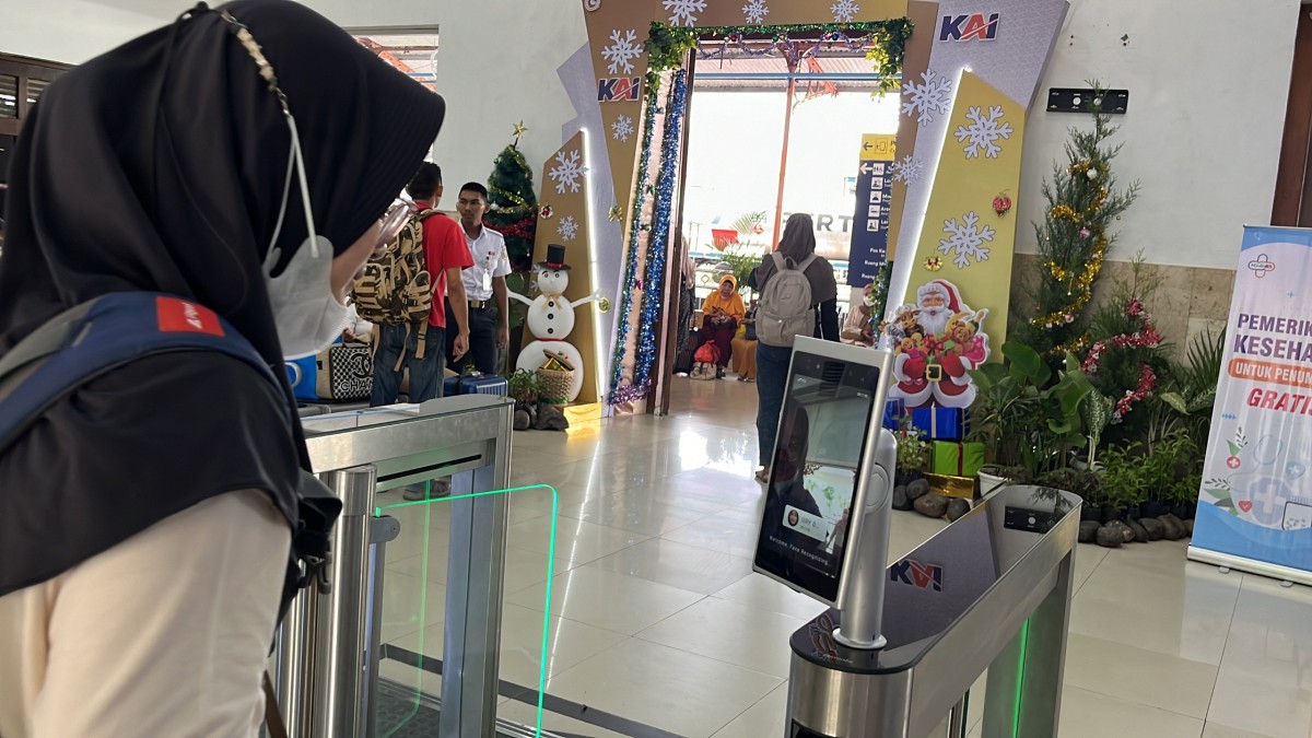 Seorang penumpang dengan layanan Face Recogniton Boarding Gate atau pengenalan wajah di pintu boarding Stasiun Madiun. (Foto: Humas Daop 7 Madiun for jatimnow.com)