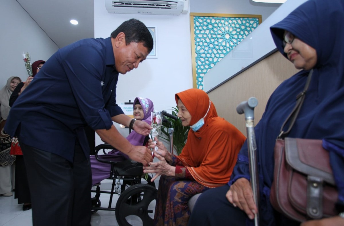 Wakil Direktur Utama BSI Bob Tyasika Ananta saat memberikan mawar merah kepada nasabah lansia (Foto: Sahlul Fahmi/jatimnow.com)