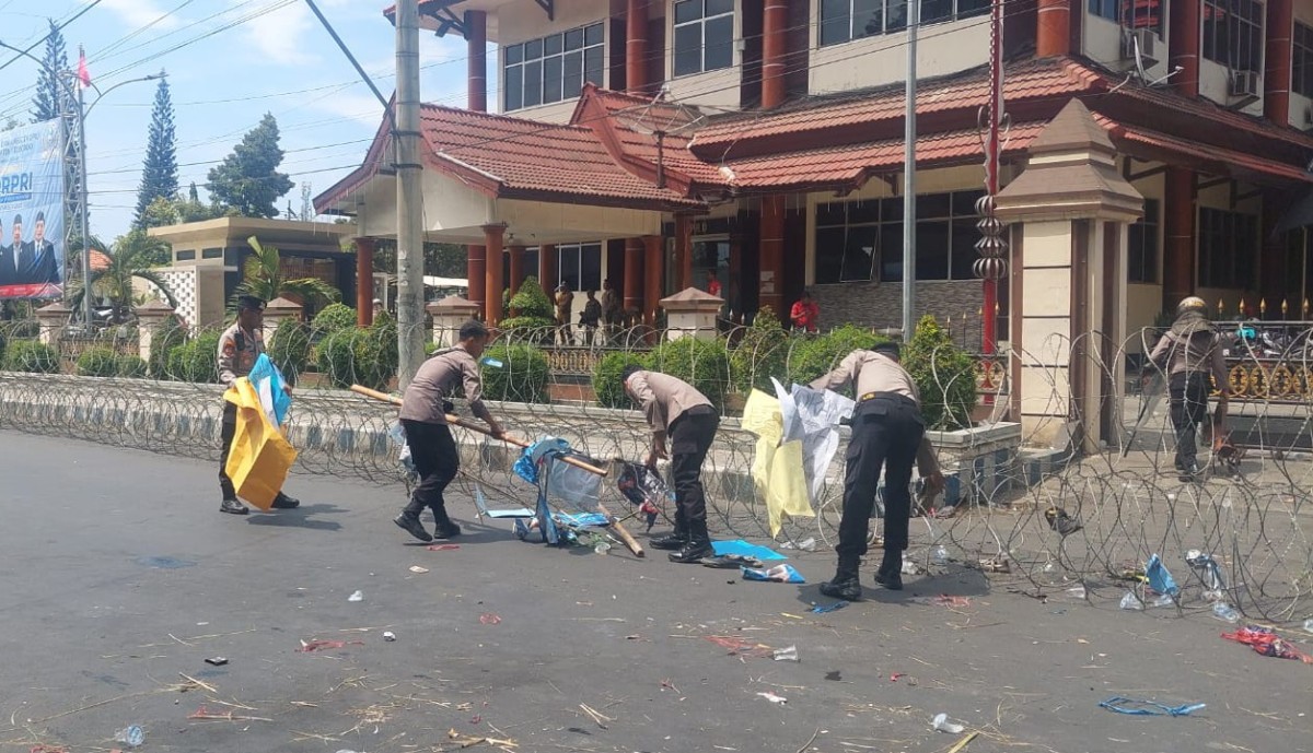 Polisi bersih-bersih sampah di halaman DPRD Situbondo. (Foto: Humas Polres Situbondo)