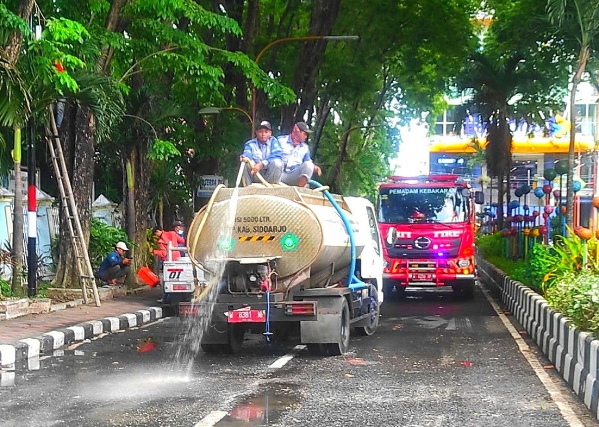 Petugas DLHK Sidoarjo membersihkan sampah sisa unjuk rasa. (Foto: Humas Pemkab Sidoarjo for jatimnow.com)