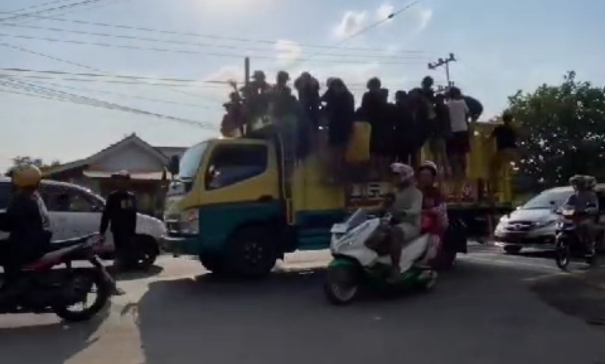 Para remaja yang menumpang kendaraan bak terbuka di akses Suramadu. (Foto: Fathor Rahman/jatimnow.com)