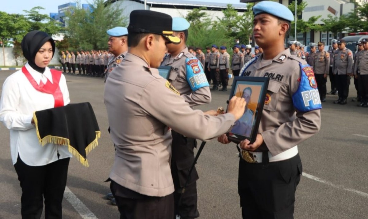 Karena tak hadir, sehingga prosesi pemecatan diwakilkan oleh personil lain dengan membawa foto Bripka S dan Bripka R. (Foto: Humas Polres Sumenep for jatimnow.com)
