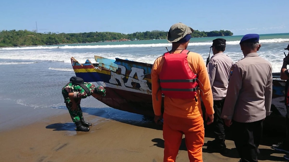 Polisi memeriksa kondisi kapal nelayan yang karam. (Foto: Bramanta Pamungkas/jatimnow.com)