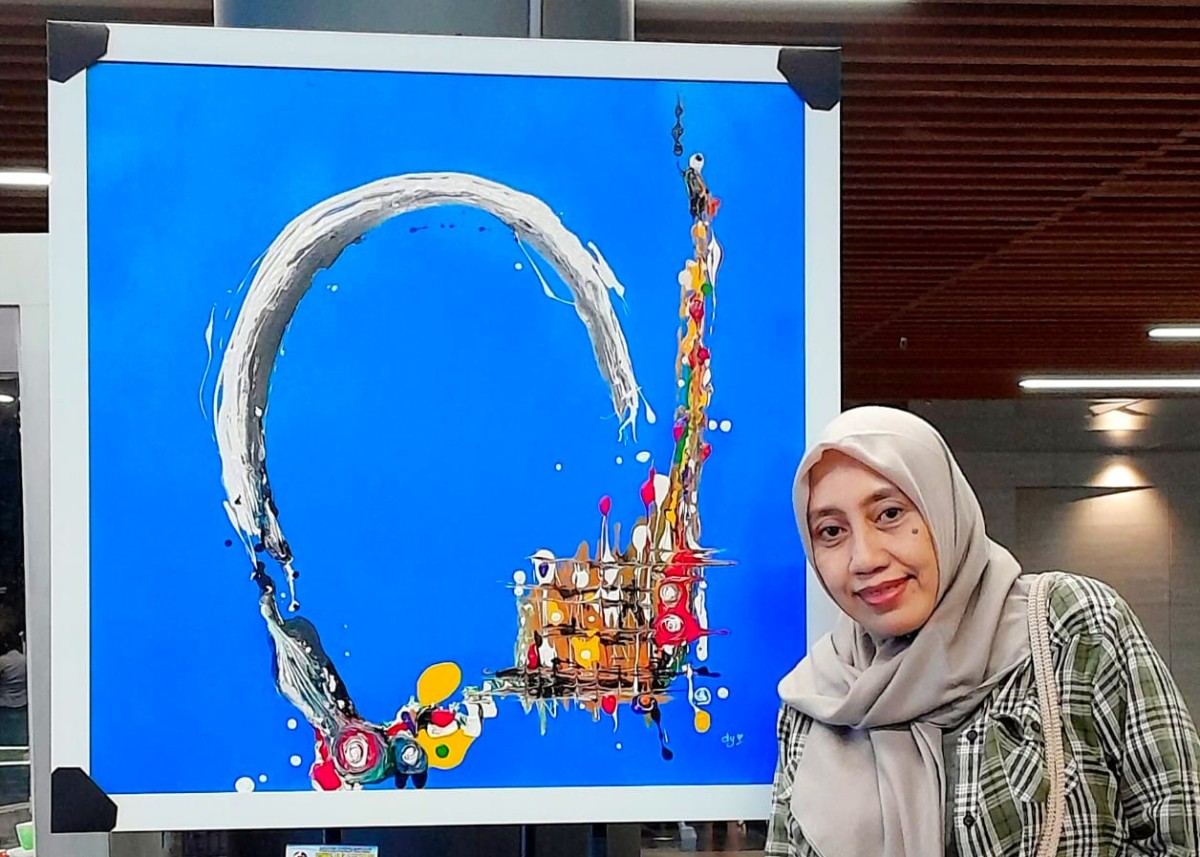 Didi Dyan (baju kotak) saat memamerkan lukisan Telenging Ati. (Foto: Dok. Didi Dyan for jatimnow.com).