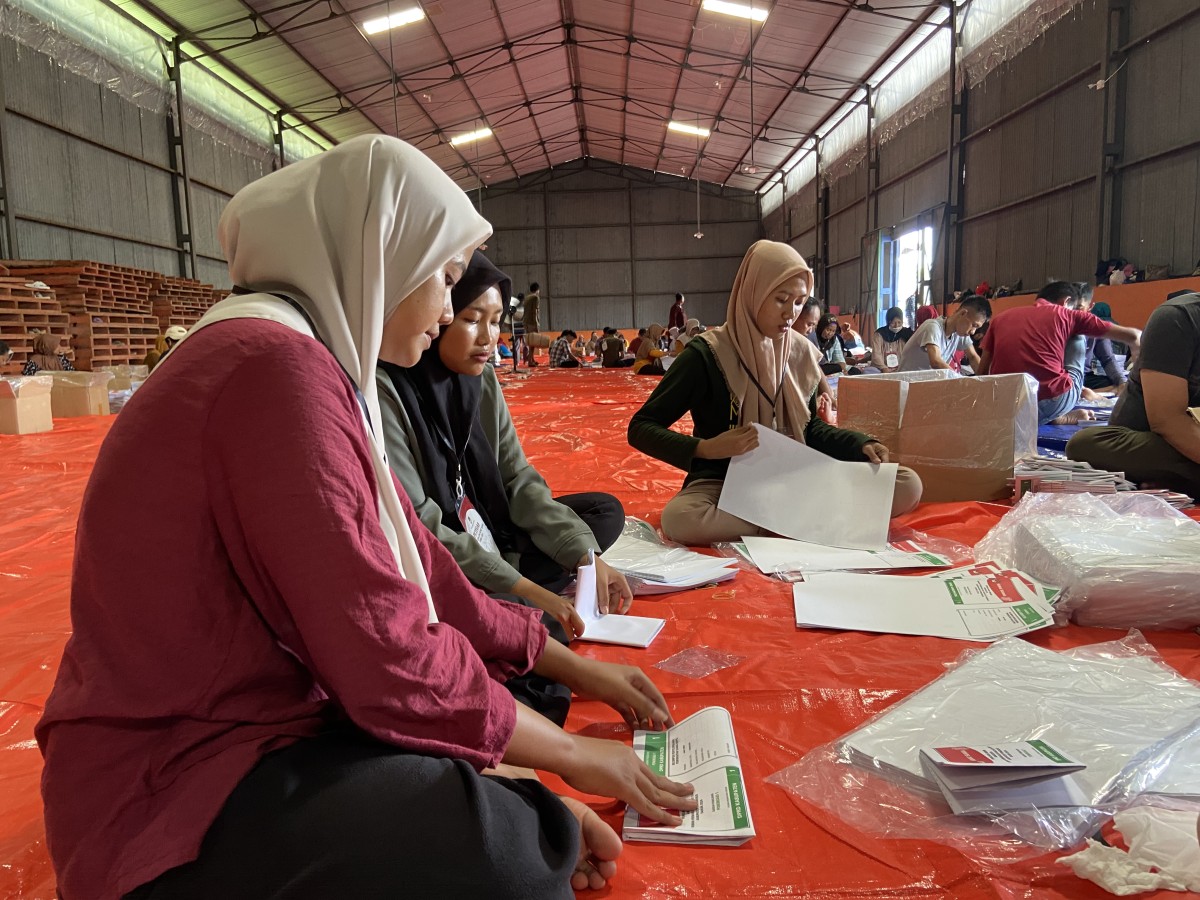 Emak-emak sedang sibuk melipat surat suara. (Foto: Ahmad Fauzani/jatimnow.com)