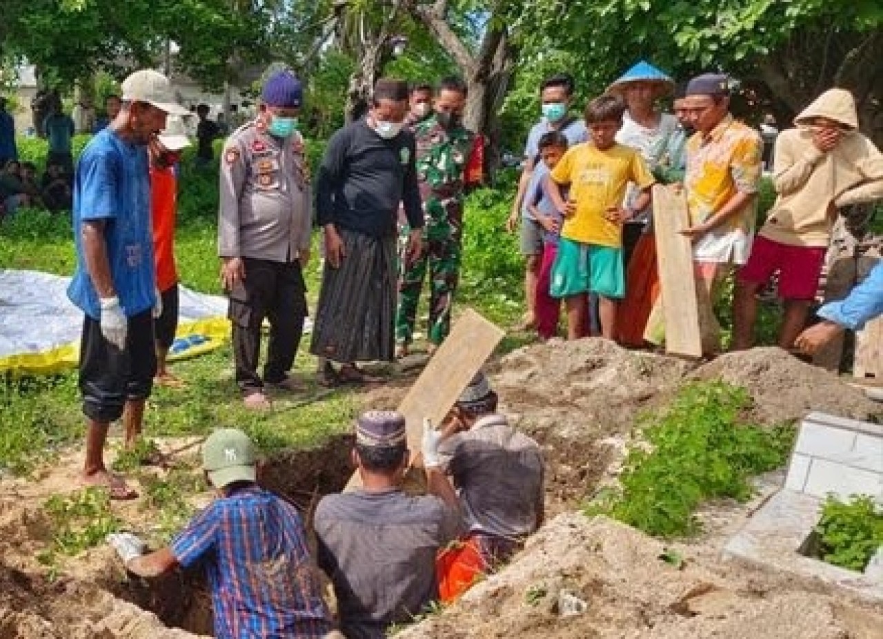Warga dan petugas memakamkan korban tenggelam KM Putra Sumber Mas, Senin (29/1/2024). (Foto: Humas Polres Sumenep for jatimnow.com)