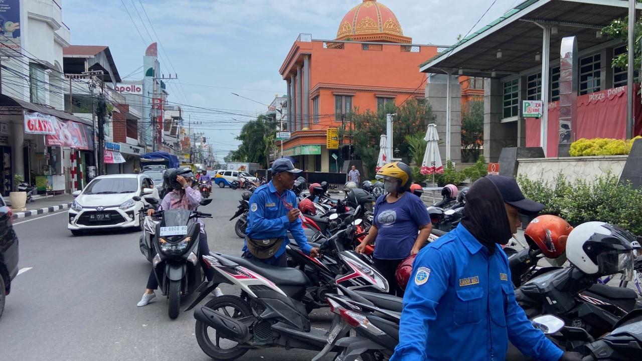 Juru parkir di Jalan Dhoho Kediri menawarkan QRIS untuk pengendara. (Foto: Yanuar Dedy/jatimnow.com)