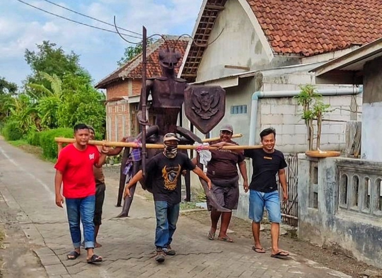 Achmad Yusril Ismal Maulana Mahendra saat mengusung patung Niscala bersama warga Desa Semut. (Foto-foto: Yusril for jatimnow.com)