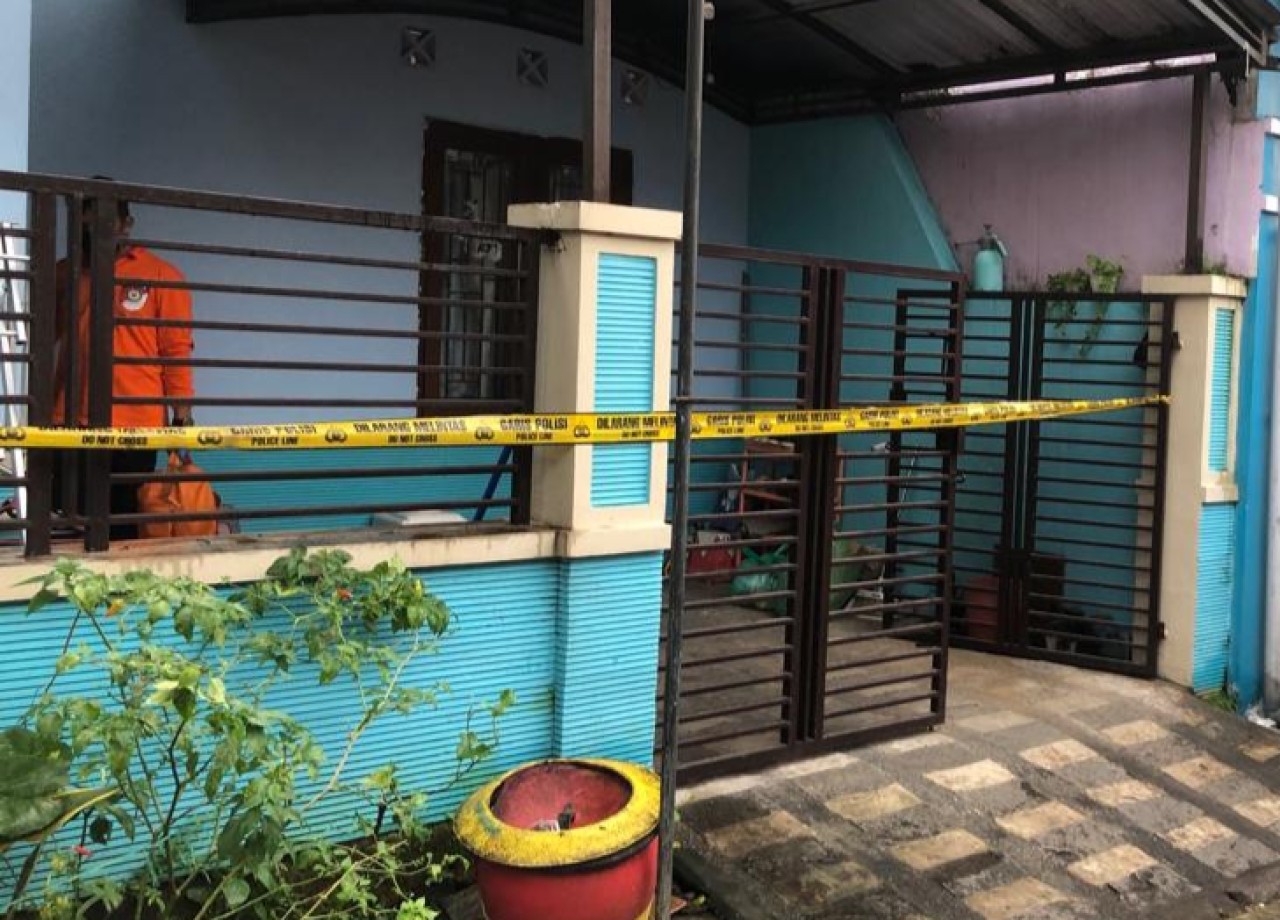 Suasana rumah yang diberi garis polisi, tempat kejadian istri tewas diduga diracun suami. (Foto: Gerhana/jatimnow.com)