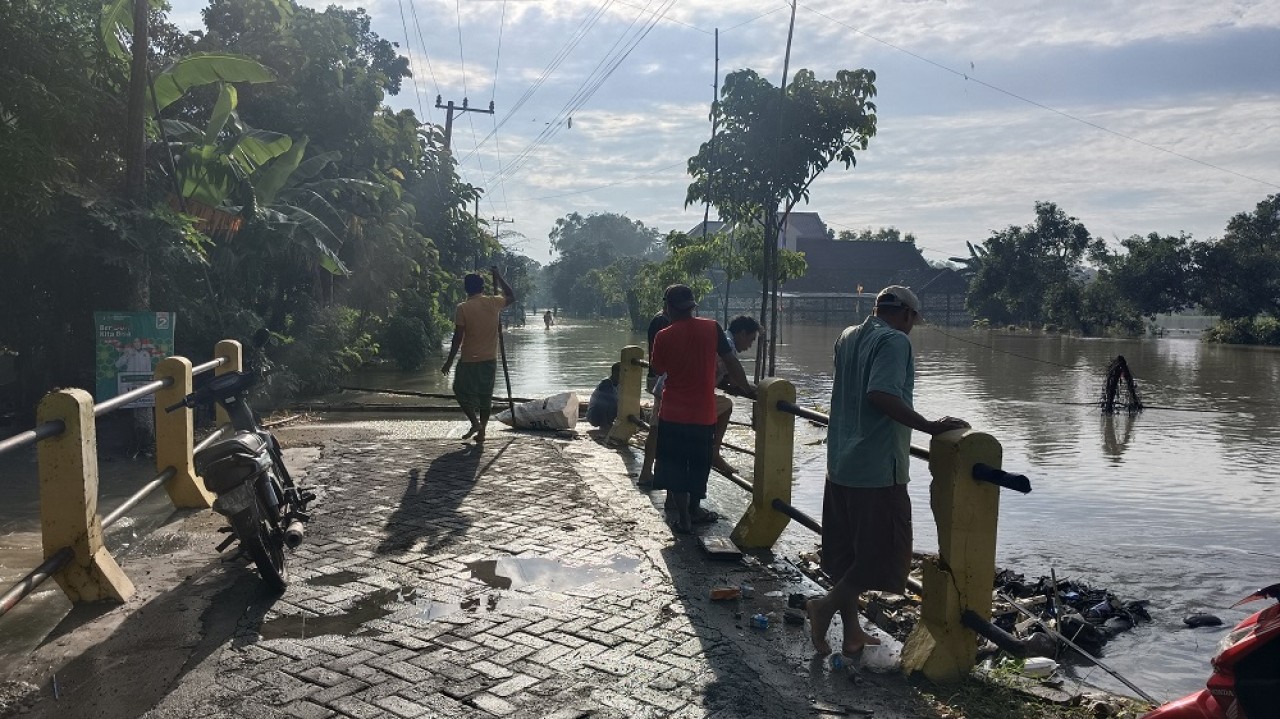 Banjir merendam jalan penghubung Desa Deru dan Sendangagung Kecamatan Sumberejo. (Foto: Misbahul Munir/jatimnow.com)
