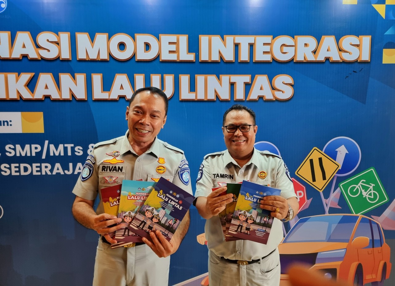 Direktur Utama PT Jasa Raharja Rivan Achmad (kiri) saat menunjukkan buku wawasan lalulintas yang akan mulai terdistribusi ke sekolah-sekolah di Surabaya (foto: Ni'am Kurniawan/jatimnow.com)
