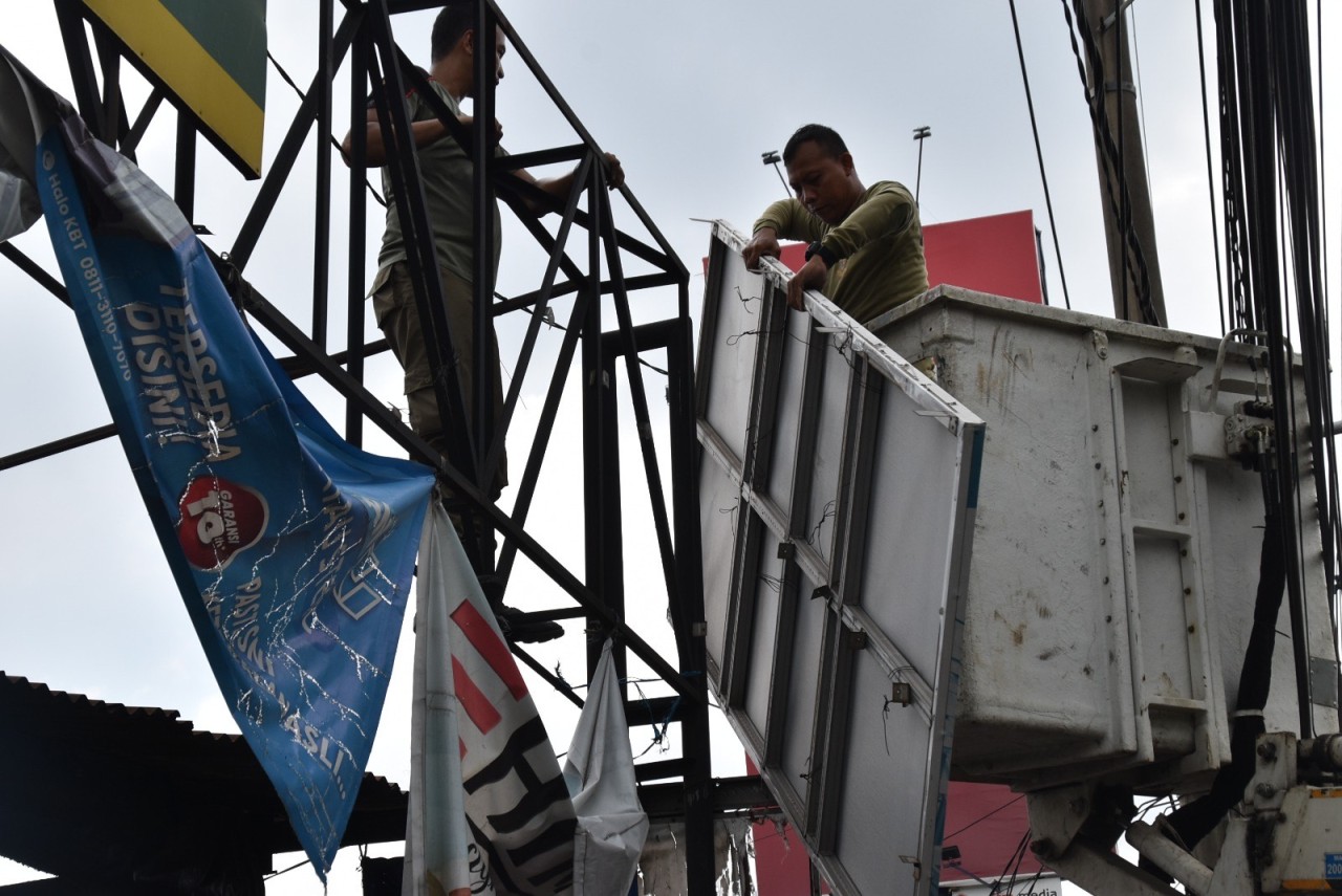 Satpol PP Surabaya saat melucuti sejumlah reklame di jalanan Surabaya (foto: Humas Pemkot Surabaya for jatimnow.com)