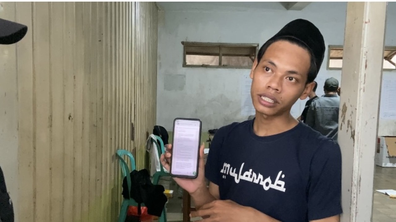 Petugas KPPS di TPS lokasi khusus Ponpes Lirboyo menunjukkan gangguan Sirekap. (Foto: Yanuar Dedy/jatimnow.com)