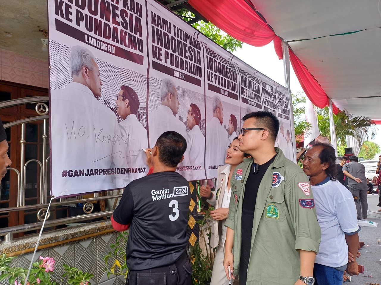 Jubir TPN Ganjar-Mahfud, Pangeran Siahaan dan Putri Jasmin saat menampung keluhan warga Lamongan dalam media tulis banner. (Foto : Adyad Ammy Iffansah/jatimnow.com)