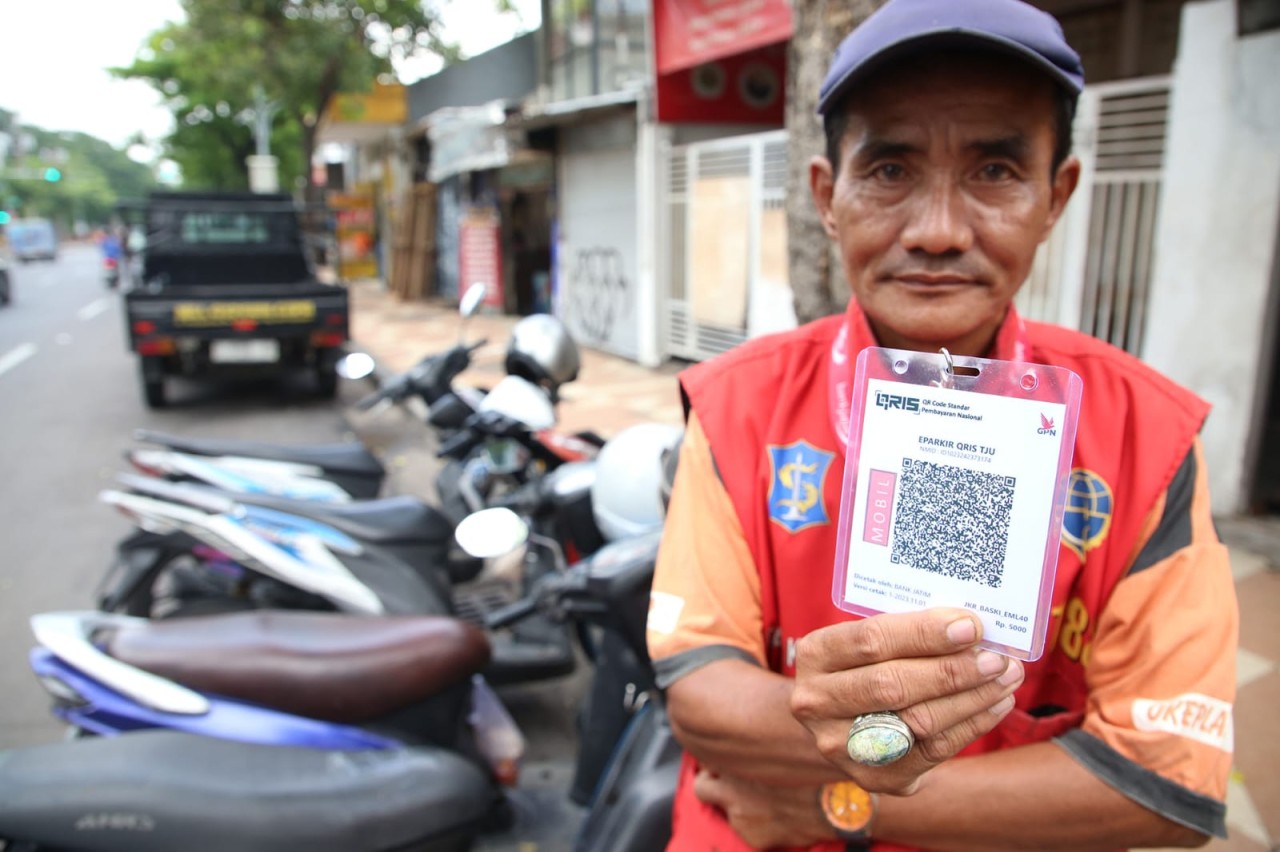 Jukir menunjuukan barcode QRIS. (Foto: Haryo Agus/jatimnow.com)