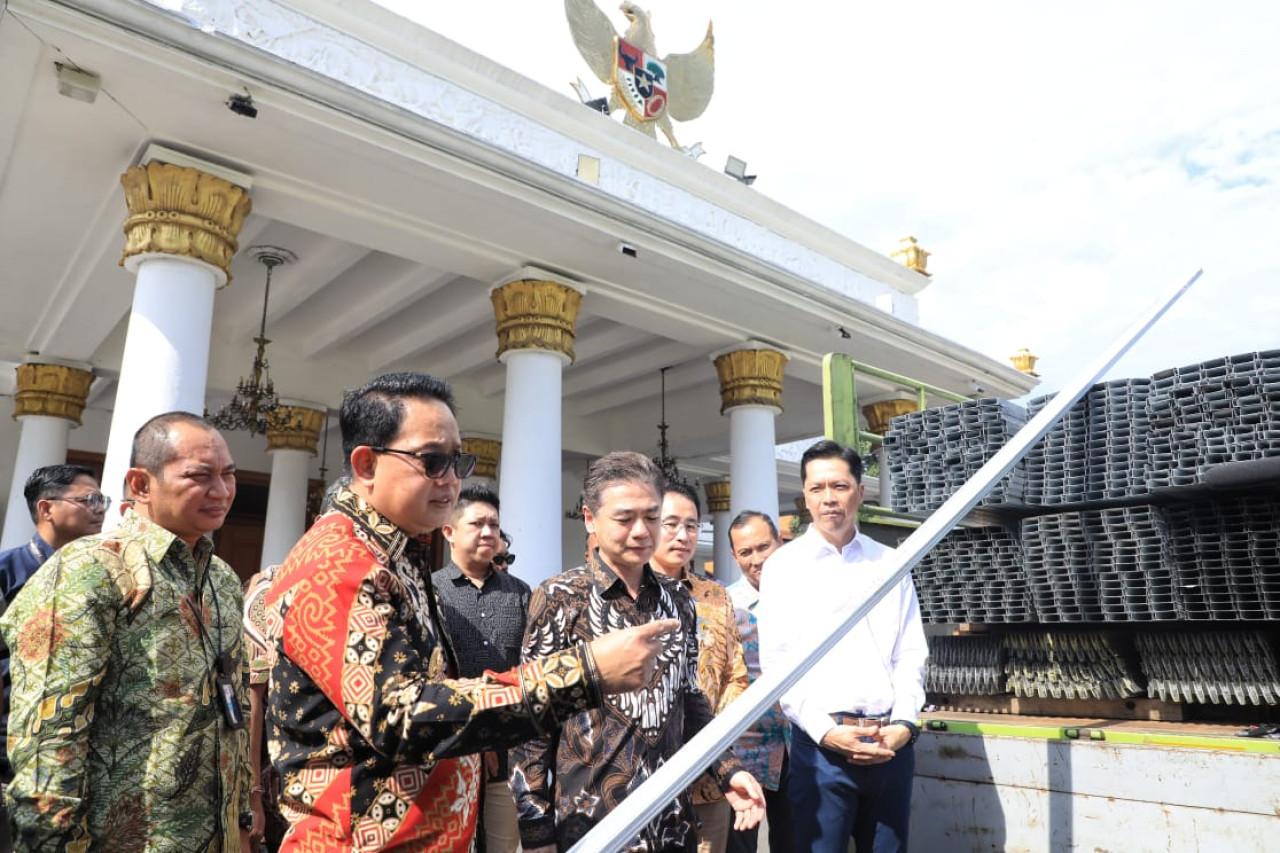 Adhy Karyono (kiri) bersama Presiden Direktur PT Kepuh Kencana Arum Henry Setiawan (tengah) saat melihat baja ringan untuk warga Bawean di Grahadi (foto: Humas Pemprov Jatim for jatimnow.com)
