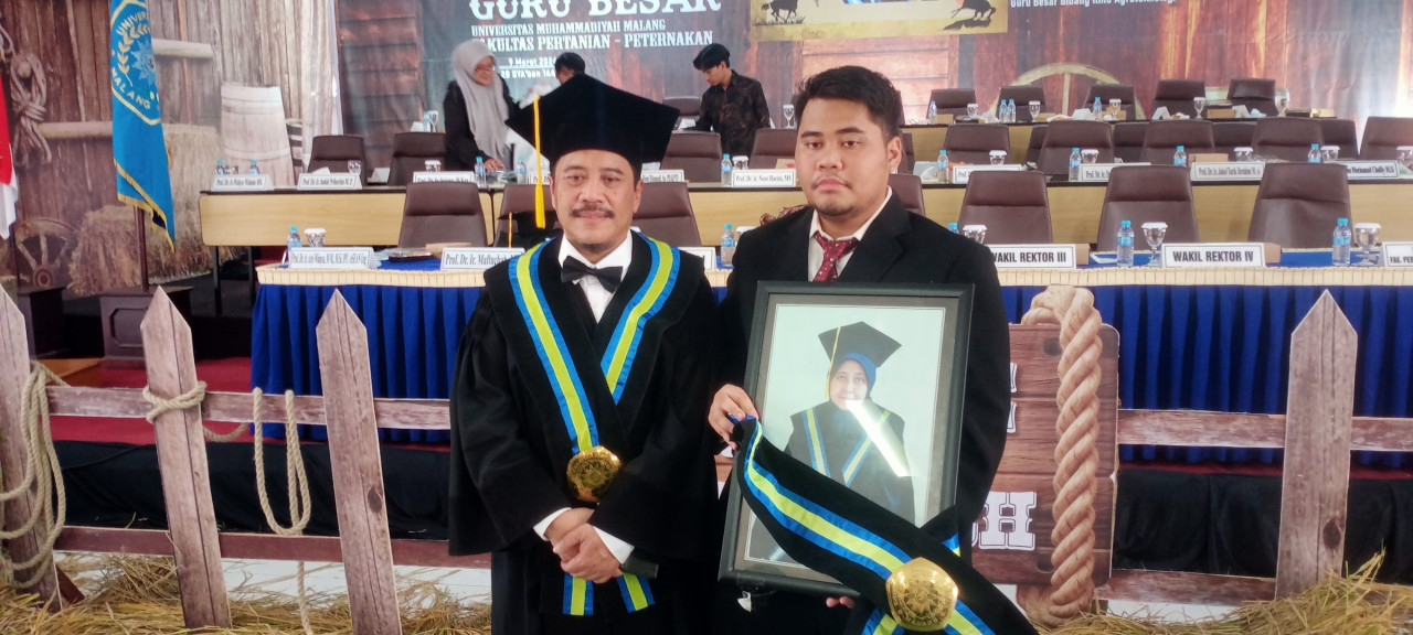 Prof. Dr. Ir. Aris Winaya, M.M., M.Si., IPU, ASEAN Eng (kiri) ditemani anaknya yang memegang foto ibunda tercinta yakni Prof. Dr. Ir. Maftuchah, M.P yang diberi penghargaan sebagai guru besar anumerta. (Foto: UMM for jatimnow.com)