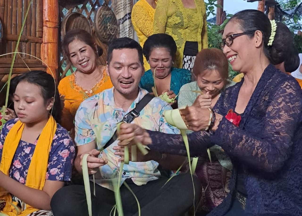Artis Evan Sanders bersama warga di Kampung Budaya Polowijen (KBP), Kota Malang sedang membuat wadah dari dedaunan, beberapa waktu lalu. (Foto : Gerhana/jatimnow.com)