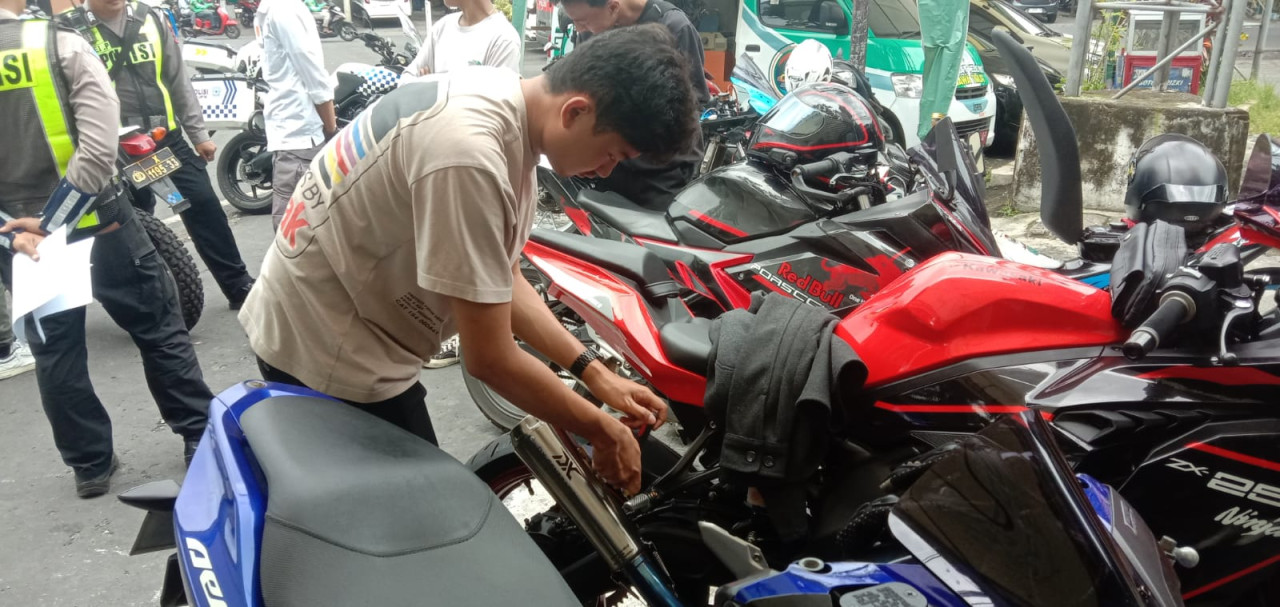 Polisi dari Satlantas Polresta Malang Kota melakukan Operasi Keselamatan Semeru 2024 dengan sasaran penertiban kendaraan yang tidak sesuai spesifikasi standar aturan. (Foto: Gerhana/jatimnow.com)