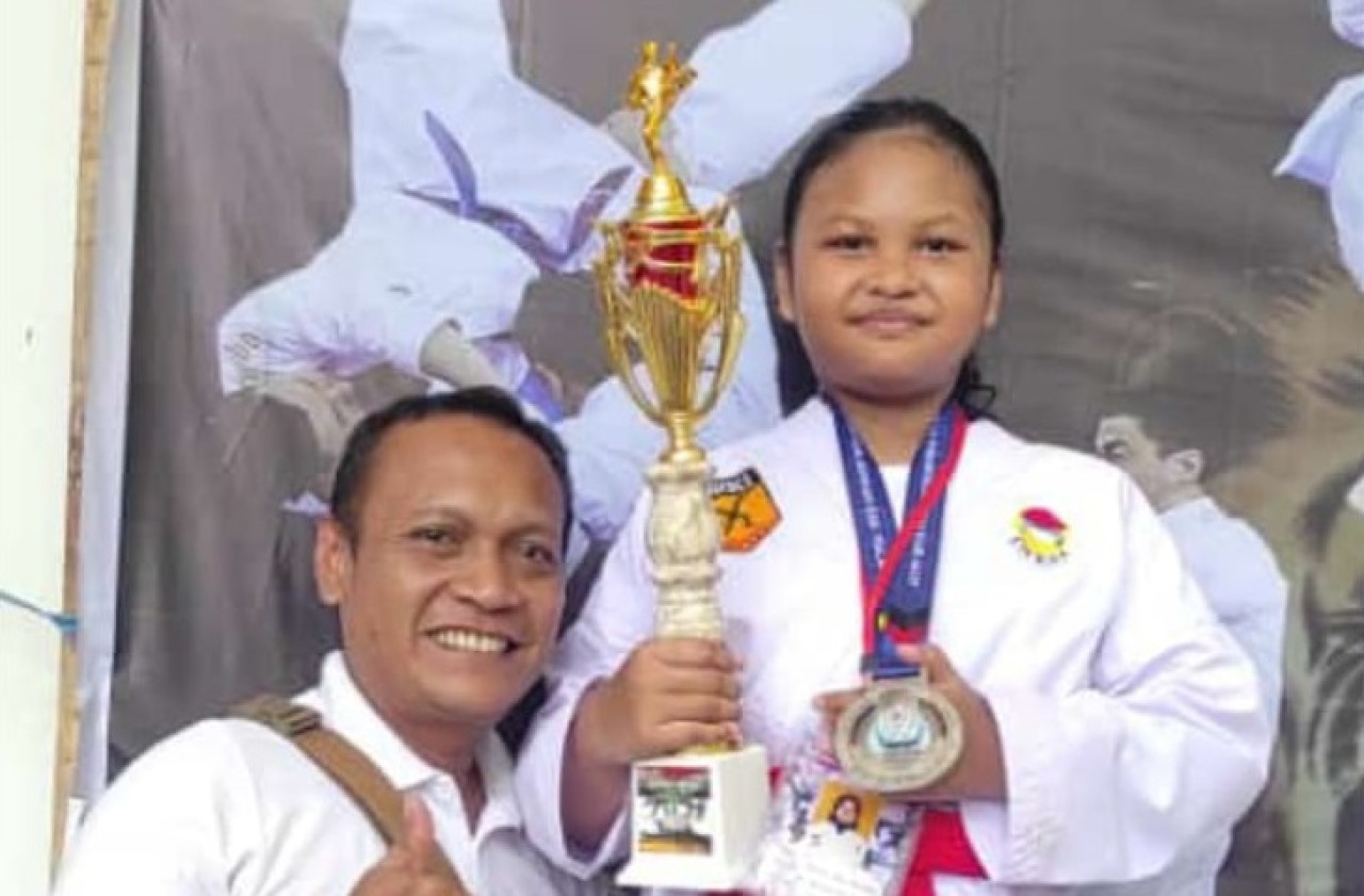Putri Dinda Aura Ramadhani saat menerima penghargaan di Piala Kemenpora RI Ajang Kejuaraan Jatim Open 2024 didampingi oleh orang tuanya. (Foto: Mahfud Hidayatullah/jatimnow.com)