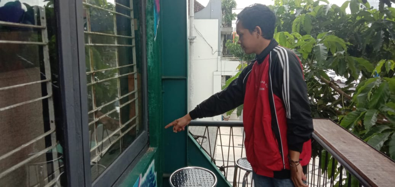 Salah satu pegawai Kafe Masple Kayutangan Coffee dan Gelato menunjukkan lokasi pelaku yang membobol jendela dan kemudian menuju lantai dasar serta langsung mengarah ke area penjualan rokok. (Foto: Gerhana/jatimnow.com)