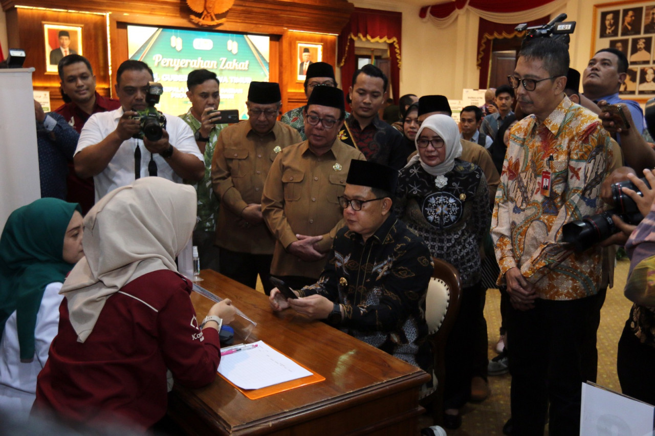 Adhy Karyono saat mengawali membayar zakat di booth yang telah disediakan Baznas bekerja sama dengan Bank Jatim. (Foto: Ni'am Kurniawan/jatimnow.com)