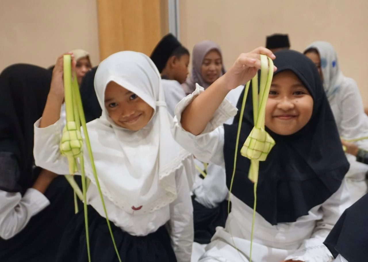 Peserta menganyam janur memperlihatkan ketupat hasil karyanya. (Foto-foto: Ahaddiini HM/jatimnow.com)