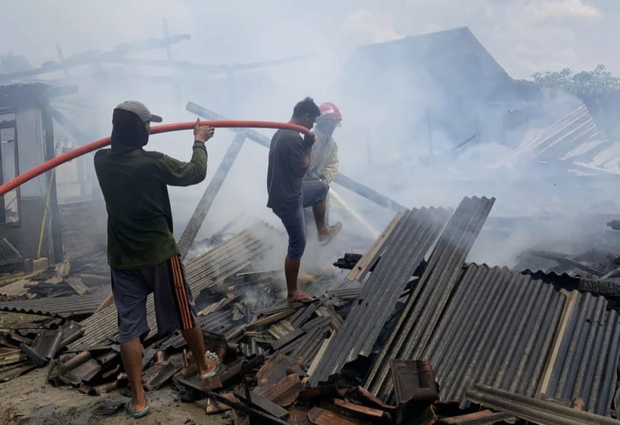 Petugas Damkarmat Bojonegoro saat memadamkan kebakaran dan pembasahan dirumah Sukardi warga Desa Gayam Bojonegoro (Foto: Misbahul Munir/jatimnow.com)