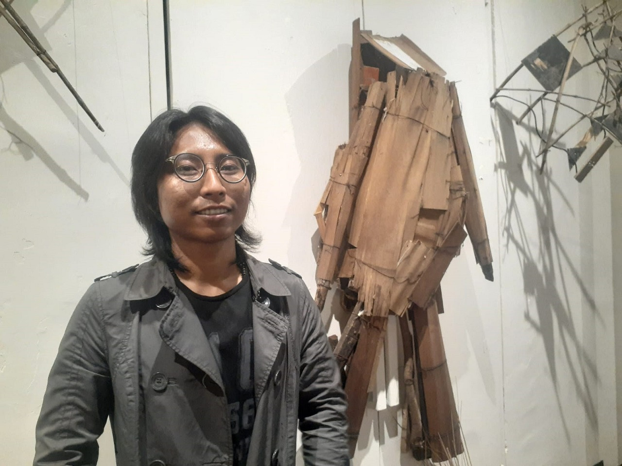 Perupa Ahmad Faisal Amir di depan salah satu karya yang dipamerkan di Galeri DKS. (Foto: Endang Pergiwati/jatimnow.com)