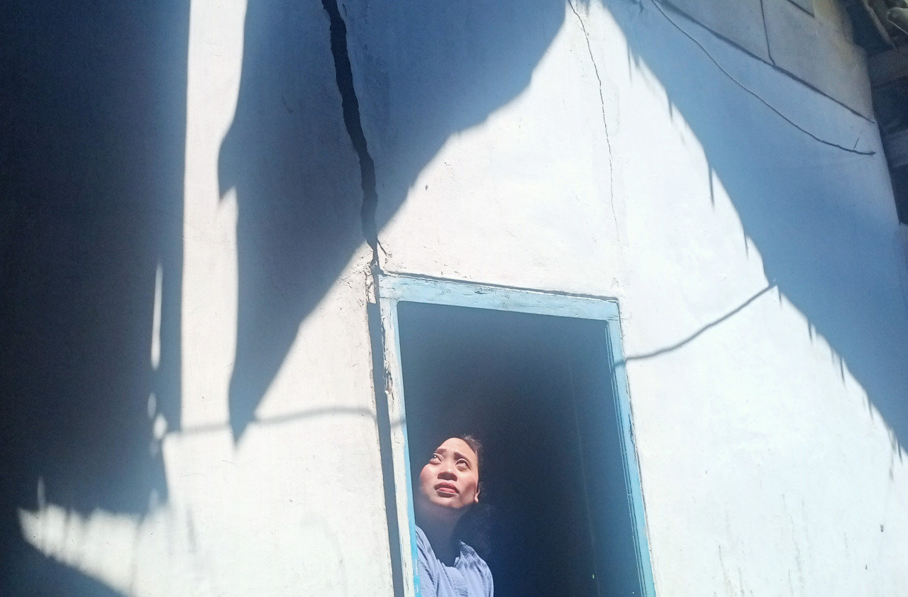 Salah satu warga RT 01 RW 10 Dusun Brau, Siti Kholifah menunjukkan keretakan bangunan rumahnya. (Foto : Gerhana/jatimnow.com)