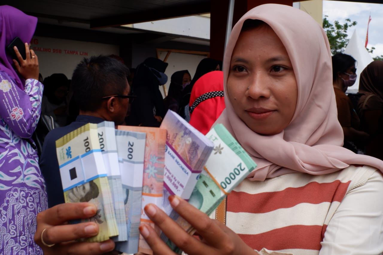 Warga memamerkan uang baru untuk lebaran. (Foto: Bramanta Pamungkas/jatimnow.com)