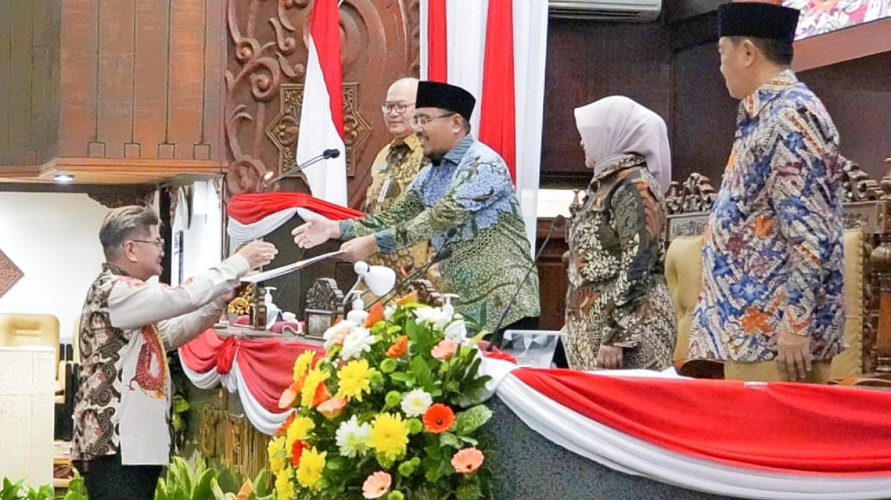 Juru bicara Fraksi Gerindra Jatim, dr Benyamin Kristanto, menyerahkan pandangan umum fraksi kepada pimpunan sidang Anwar Sadad. (Foto: Humas DPRD Jatim)