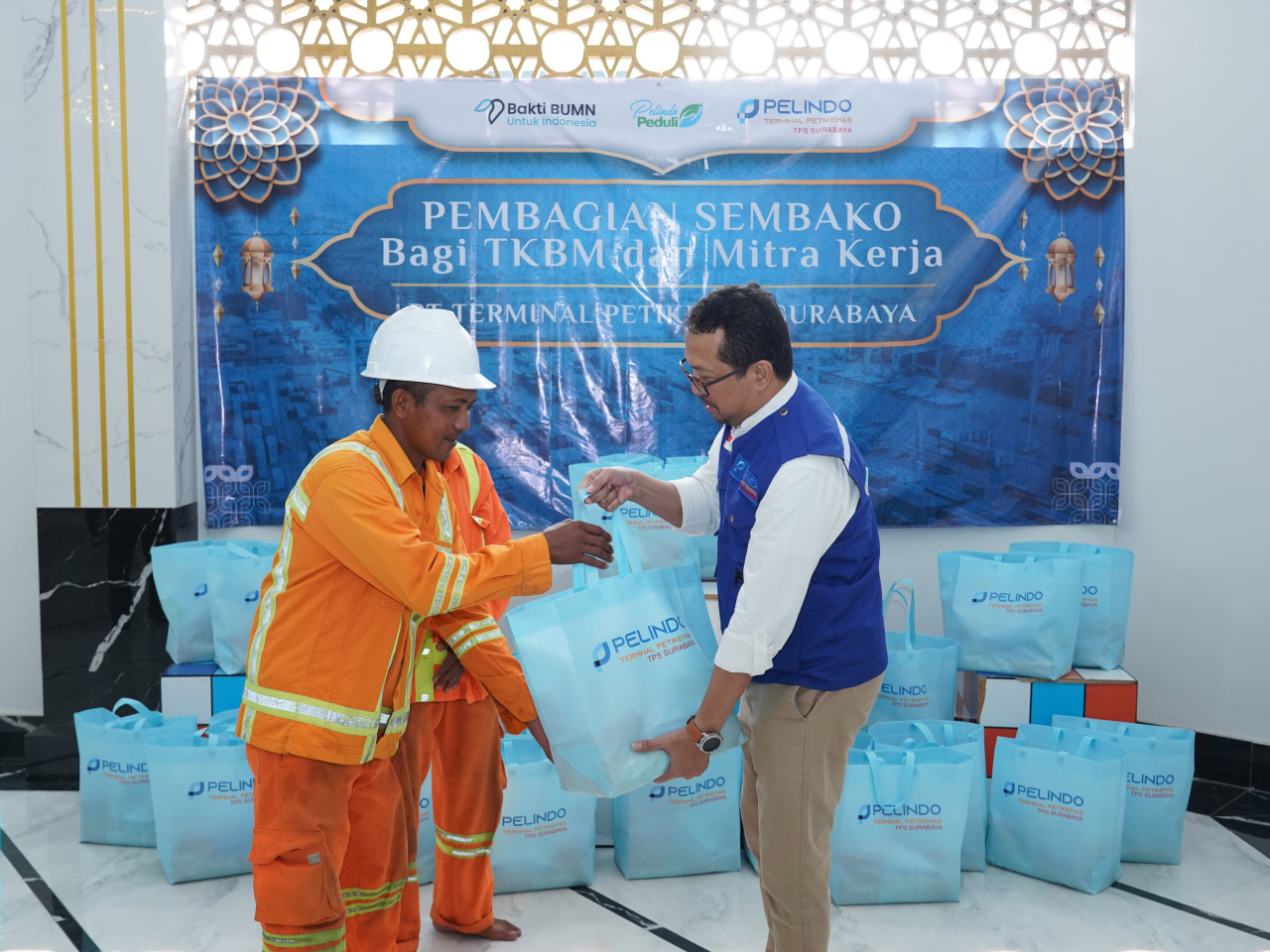 Direktur Utama PT Pelindo Terminal Petikemas memberikan bingkisan sembako secara simbolis pada perwakilan tenaga kerja bongkar muat. (Foto: Humas Pelindo for jatimnow.com)