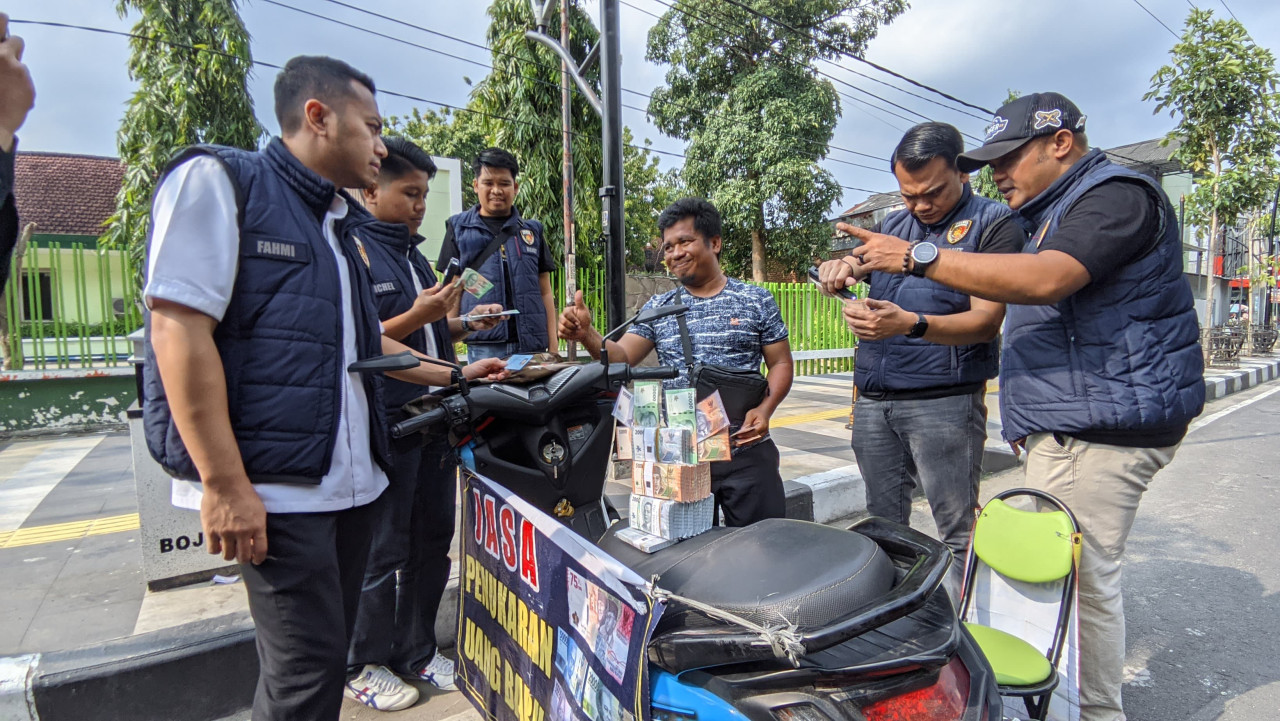 Kasatreskrim Polres Bojonegoro AKP Fahmi Amarullah bersama jajaran saat melakukan pemeriksaan di lapak jasa penukaran uang baru yang berada di sekitar Kecamatan Kota Bojonegoro (dok Rizky for jatimnow.com)