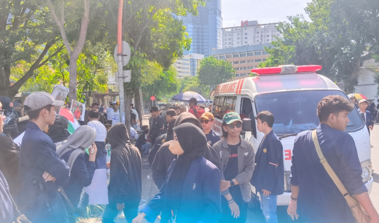 Sejumlah mahasiswa Unesa saat mengamankan rekannya yang alami sesak nafas. (Foto: Misbahul Munir/jatimnow.com)