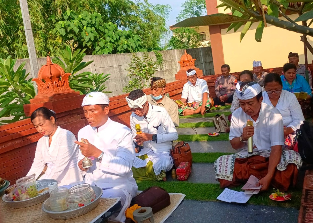 Anggota polisi beserta umat Hindu melaksanakan ibadah Hari Suci Tilem. (Foto: Ahaddiini HM/jatimnow.com).