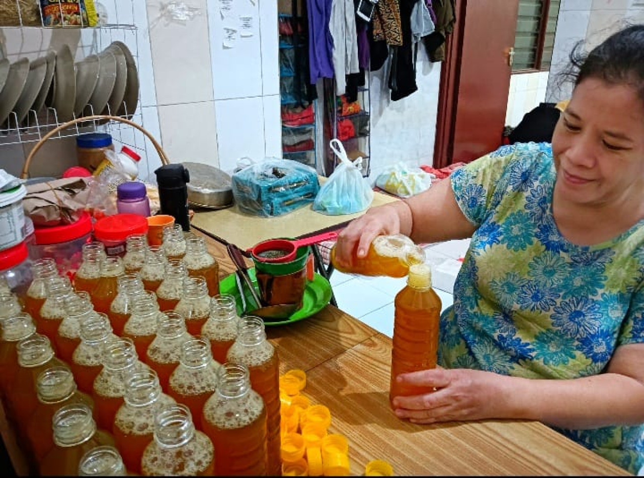 Loe Liang Fang warga Villa Jasmine l Suko Sidoarjo saat memproduksi Jamu Segar Dingin Boenda Jasmine. (Foto: Ahaddiini HM/jatimnow.com)